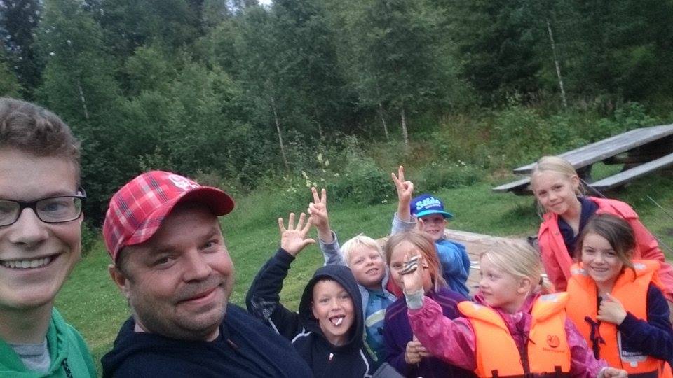 2 &laquo;voksne&raquo; og 7 barn ved et lite badetjern i skogen.